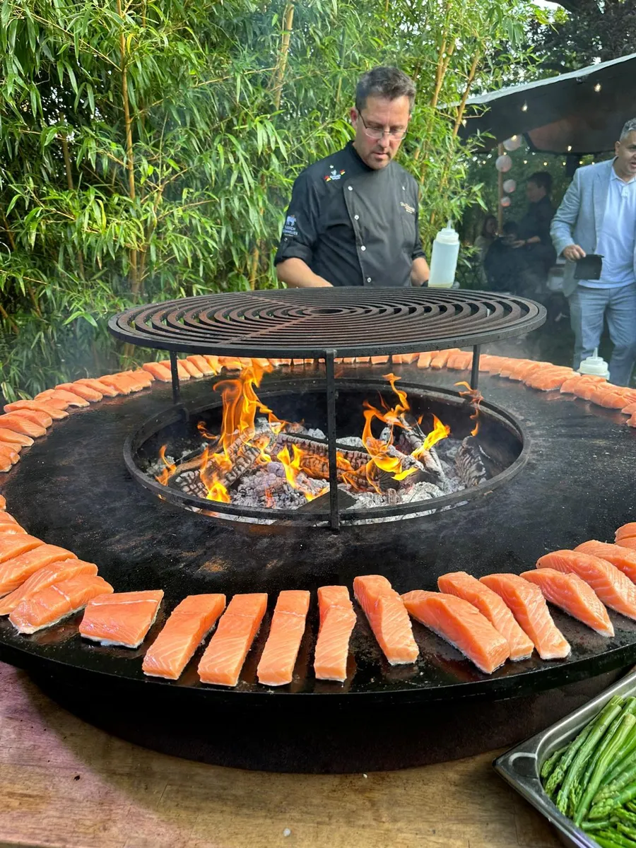 Jürgen Reck grillt Bratwürste auf einem Feuerring