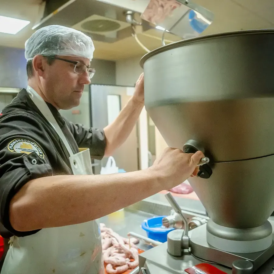 Jürgen Reck füllt Bratwurstbrät an der Füllmaschine